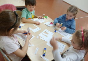 Dzieci siedzą przy stoliku i rozwiązują sudoku obrazkowe